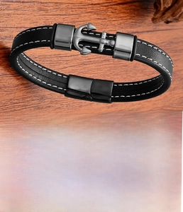 Detail view of leather bracelet with stainless steel anchor clasp on wood background