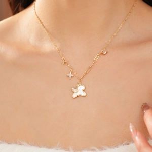Detail of gold necklace with white unicorn, sparkling star, and planet charms on model