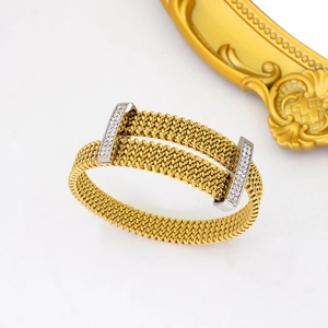 Detail of gold mesh woven bracelet featuring silver clasp with sparkling cubic zirconia