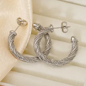 Classic 18K silver stainless steel twisted hoop earrings in a beige jewelry box