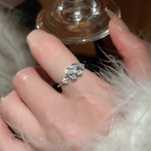 Close-up of elegant silver flower ring with sparkling crystals on a white feather
