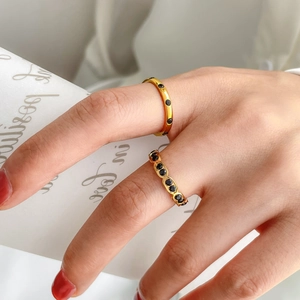 Golden rings set featuring black enamel heart and pave black crystals on model