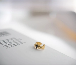 Detailed view of 18K gold plated ring featuring hammered texture and black teardrop stone