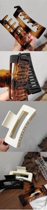 Detail view of large matte hair claws in tortoiseshell, cream, and black colors