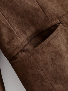 Gros plan détaillé du tissu en daim vert olive montrant les coutures de poche précises