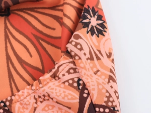 Detail view of orange floral paisley fabric with fine stitching on the vacation set