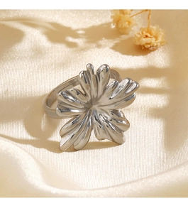 Detailed shot of an adjustable silver flower ring on elegant silk fabric background