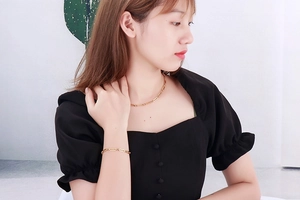 Gros plan sur un ensemble de bijoux en titane doré avec maillons rectangulaires sur mannequin