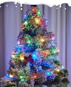 Detail of gold Christmas ribbon fairy lights with RGB LEDs on a snowy tree branch