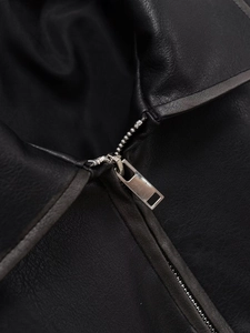 Macro shot of silver metal zipper detail and textured black leather jacket surface