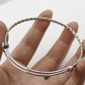 Close-up of a silver twisted wire cuff bracelet with an adjustable sliding closure design