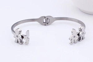 Macro detail of silver bangle featuring boy and girl silhouettes with sparkling crystals