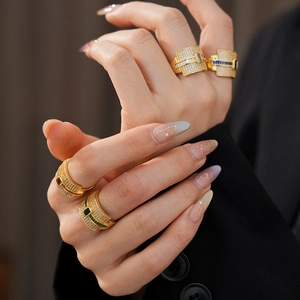 Detailed view of luxury gold square zircon rings with colorful gemstones on a model hand