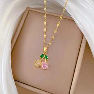 Pink crystal cherry pendant necklace in gold finish with sparkling leaf details