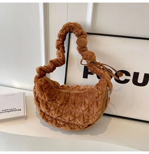 Detail of caramel pleated dumpling bag showing quilted velvet texture and zipper closure