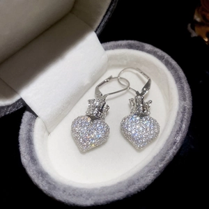 Macro shot of silver heart and crown leverback earrings with zircon stone pavé setting