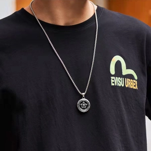Detail of a silver stainless steel twisted chain necklace with star engraved pendant