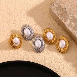 Detailed view of vintage gold and silver oval pearl earrings with wheat pattern texture