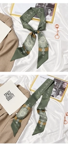 Detail of green silk scarf with sun moon and star patterns on white silk background
