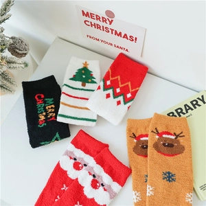 Gros plan de chaussettes de Noël en polaire corail avec motifs festifs et décorations