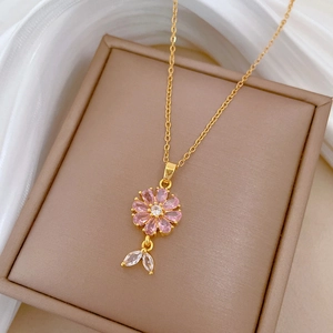 Detail of pink crystal flower necklace with leaf pendants on brown jewelry box