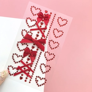 Macro shot of red ribbon bows and heart crystal rhinestones for fairy eye makeup art