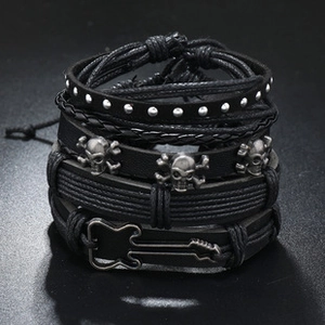 Set of four black leather bracelets featuring skull charms and a guitar shaped metal clasp
