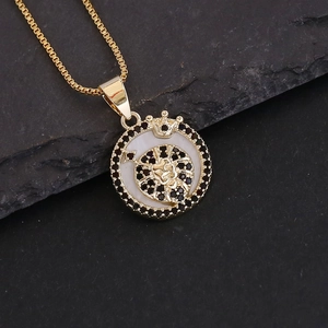 Detail of 18K gold constellation necklace with white shell inlay on black stone background