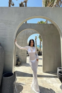 Détail d'une robe de plage en maille transparente blanche à manches longues en vacances
