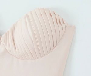 Close-up detail of pleated texture and ruched chest design on this elegant pink dress