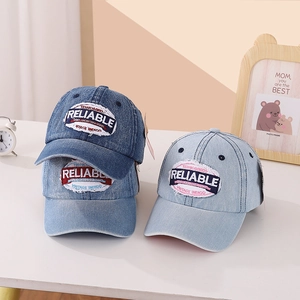 Three shades of washed denim baseball caps with vintage embroidery on a clean table