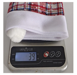 Detail view of a 39g red and white plaid Christmas car headrest cover on a digital scale