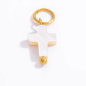 Macro shot of 18k gold cross pendant with white mother of pearl inlay and metal bail