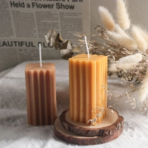 Vista macro de velas cilíndricas texturizadas con elegantes ranuras verticales
