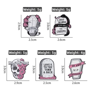 Macro shot of Gothic enamel pin set featuring pink floral coffins and skull gravestones