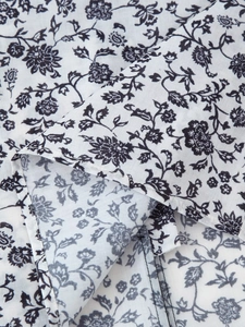 Gros plan détaillé sur l'imprimé floral noir sur un tissu en coton blanc de qualité