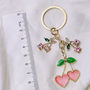 Charming pink heart cherry keychain with gold metal finish and green enamel leaf detail