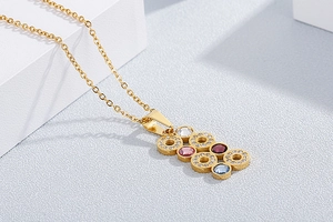 Macro shot of gold necklace featuring geometric pendants with colorful crystal rhinestones