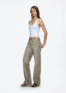 Detail of white halter neck top backless design paired with vintage wide-leg denim jeans