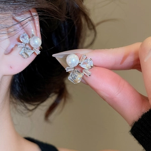Detail shot of elegant zircon flower pearl ear cuff worn on the ear bone for women
