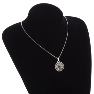 Men's silver alloy compass pendant necklace with black gemstone on a display mannequin