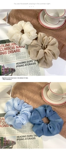 Detailed view of oversized chiffon silk scrunchies in cream and blue pastel tones