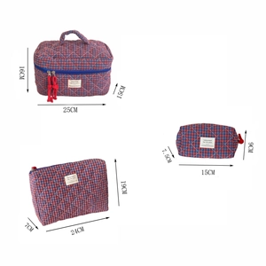 Three-piece checkered makeup bag set with red and blue quilted patterns and zip closure