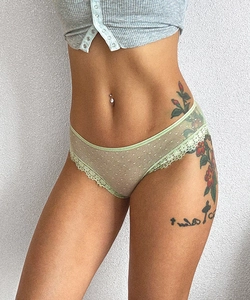 Détail de culotte en dentelle vert clair montrant les lanières et le tulle à pois