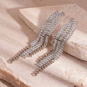 Détail de boucles d'oreilles à franges de luxe avec zircons rectangulaires et glands argentés