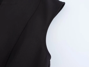 Macro shot of sleeveless black crepe mini dress showing detailed fabric texture and stitching