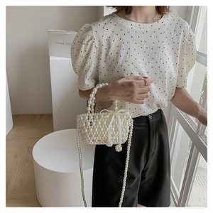 Détail du sac à main en perles avec un nœud en satin et une texture tissée