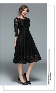 Detailed texture of black lace midi dress with hollow-out floral patterns and A-line hem