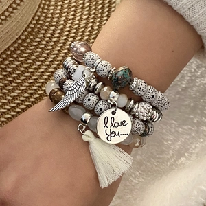 Bohemian multi-layer beaded bracelet with silver wing charm and tassel on a female wrist