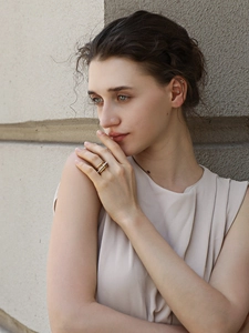 Detail of layered gold ring with white pearls and sparkling pavé stones on a model